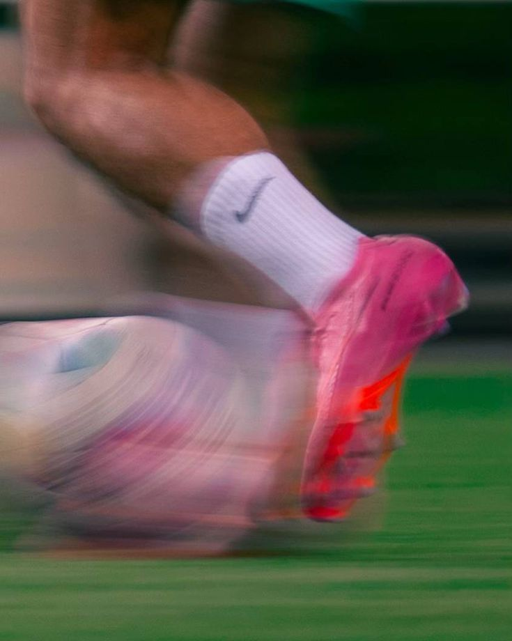 Uno scarpino rosa colpisce il pallone sul campo da calcio